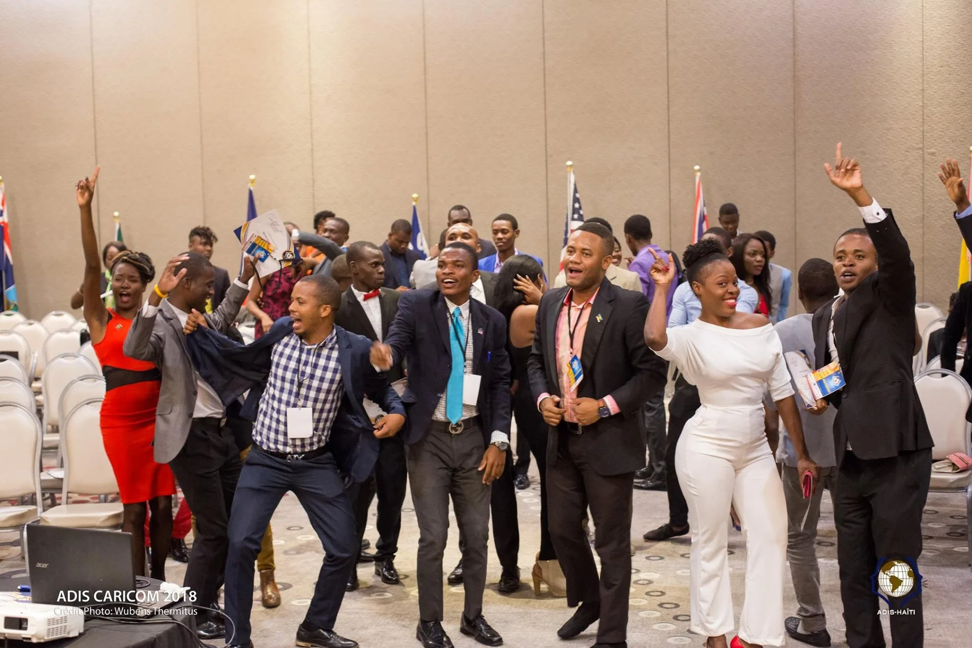 Les participants d'ADIS CARICOM 2018 debout dans la salle de conférence, bras levés dans une ambiance joyeuse