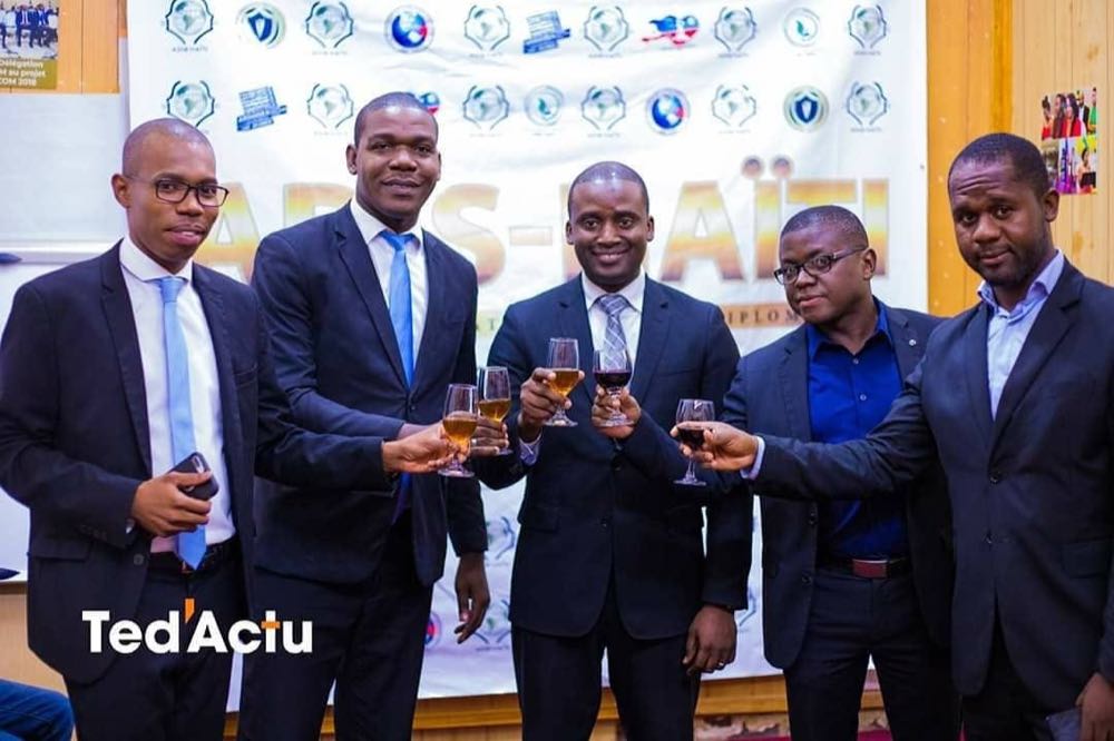 Cinq dirigeants d'ADIS-HAÏTI portant un toast lors d'une soirée officielle