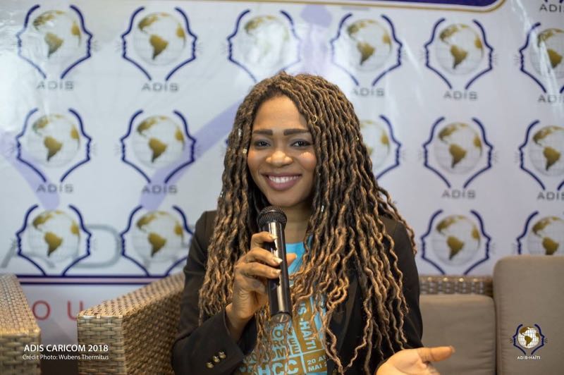 Oratrice au micro lors d'un événement ADIS CARICOM 2018