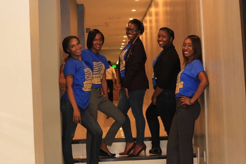 Groupe de jeunes membres d'ADIS-HAÏTI en tenue ARSHOEA dans un couloir