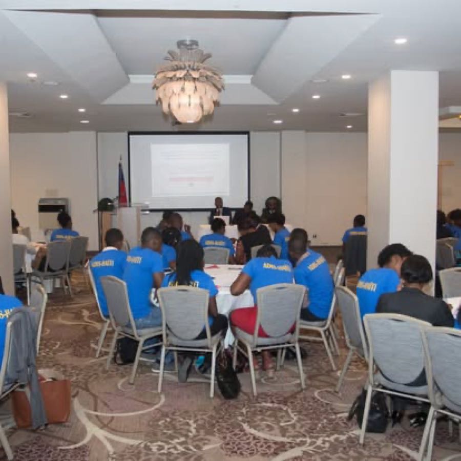 Salle de conférence avec présentation à l'écran, cours sur le repositionnement d'Haïti à l'OEA